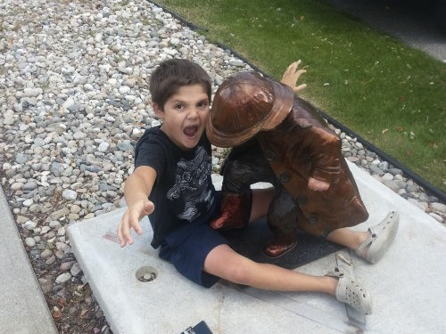 niño-jugando-con-estatua