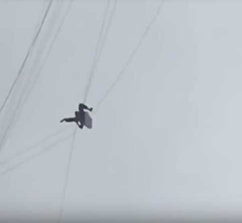 Un hombre trepa por un cable de teléfono para evitar pagar la tarifa de un hotel